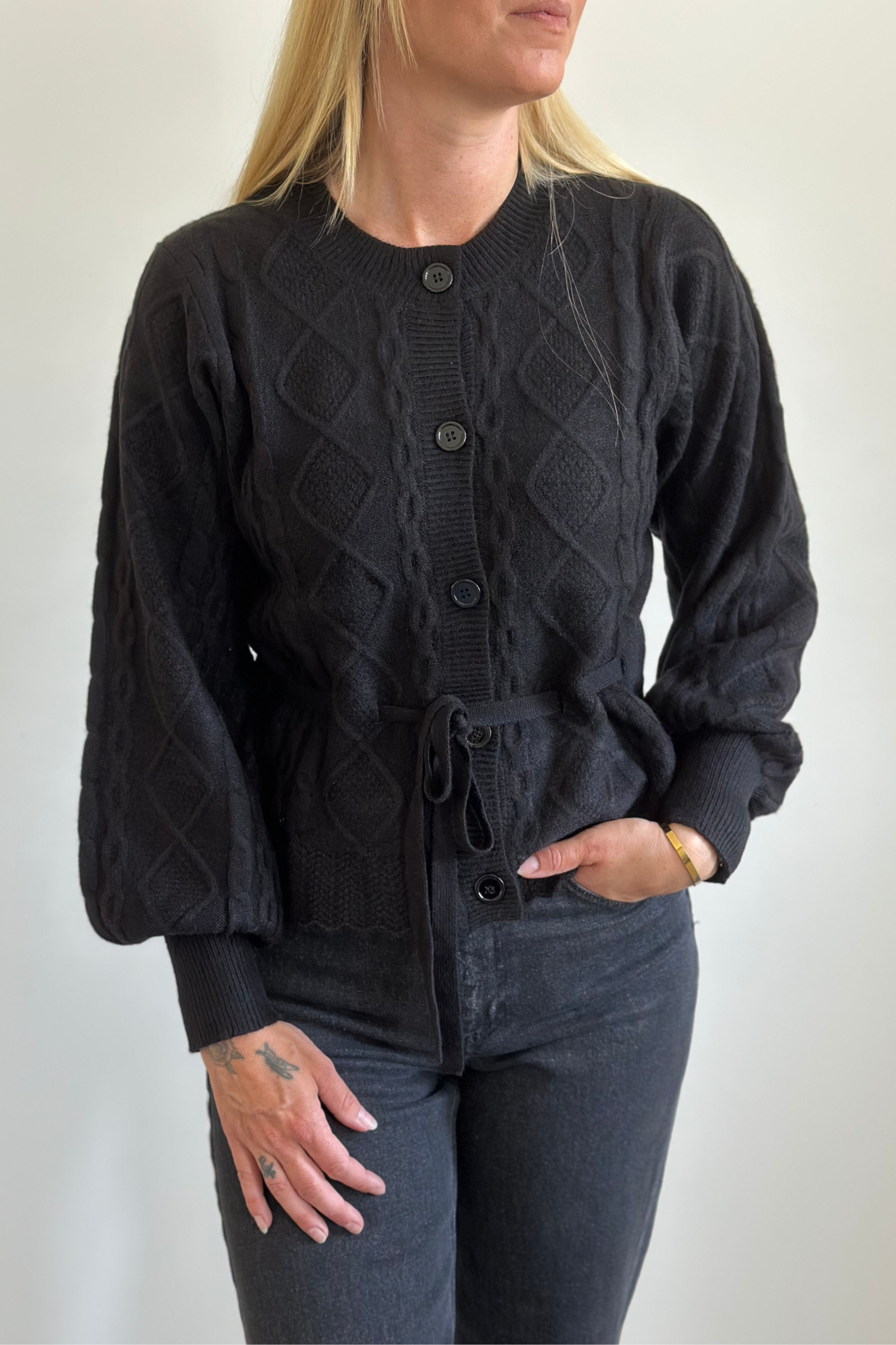 Fin, smuk, elegant, klassisk, staple, feminin, pæn, rå, cool, sej, unik, musthave, hverdag, fest, kvinde, dame, woman, strik, knit, striktrøje, bluse, pullover, trøje, mønster, pattern, ballonærmer, ib, bindebånd, bælte, blød, soft, cozy, varm, warm, black, sort